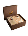 Open brown gift box with decorative items on a neutral background
